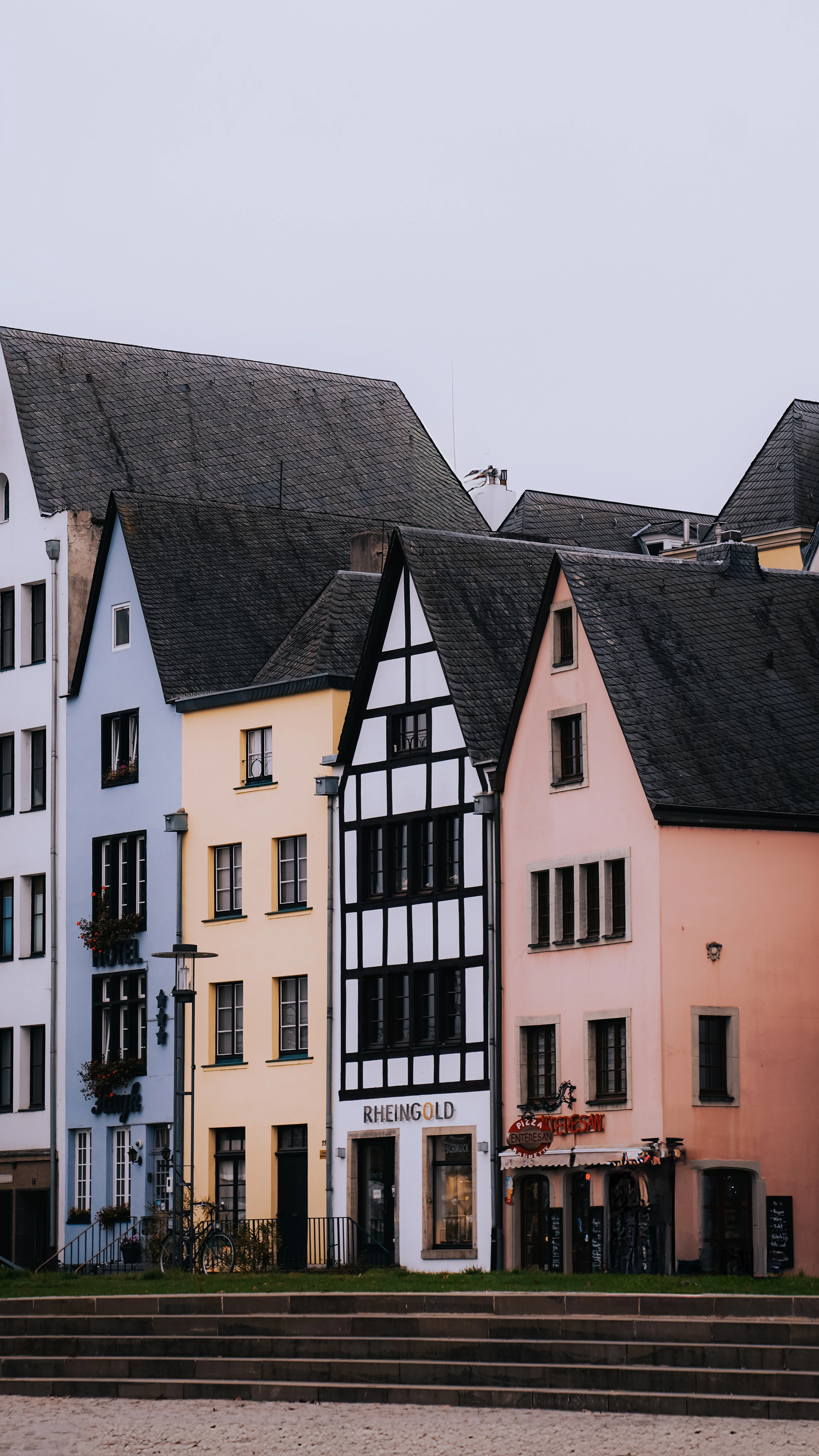 Row of colorful gabled old-town houses in Cologne, including the black-and-white timber-frame Rheingold building.