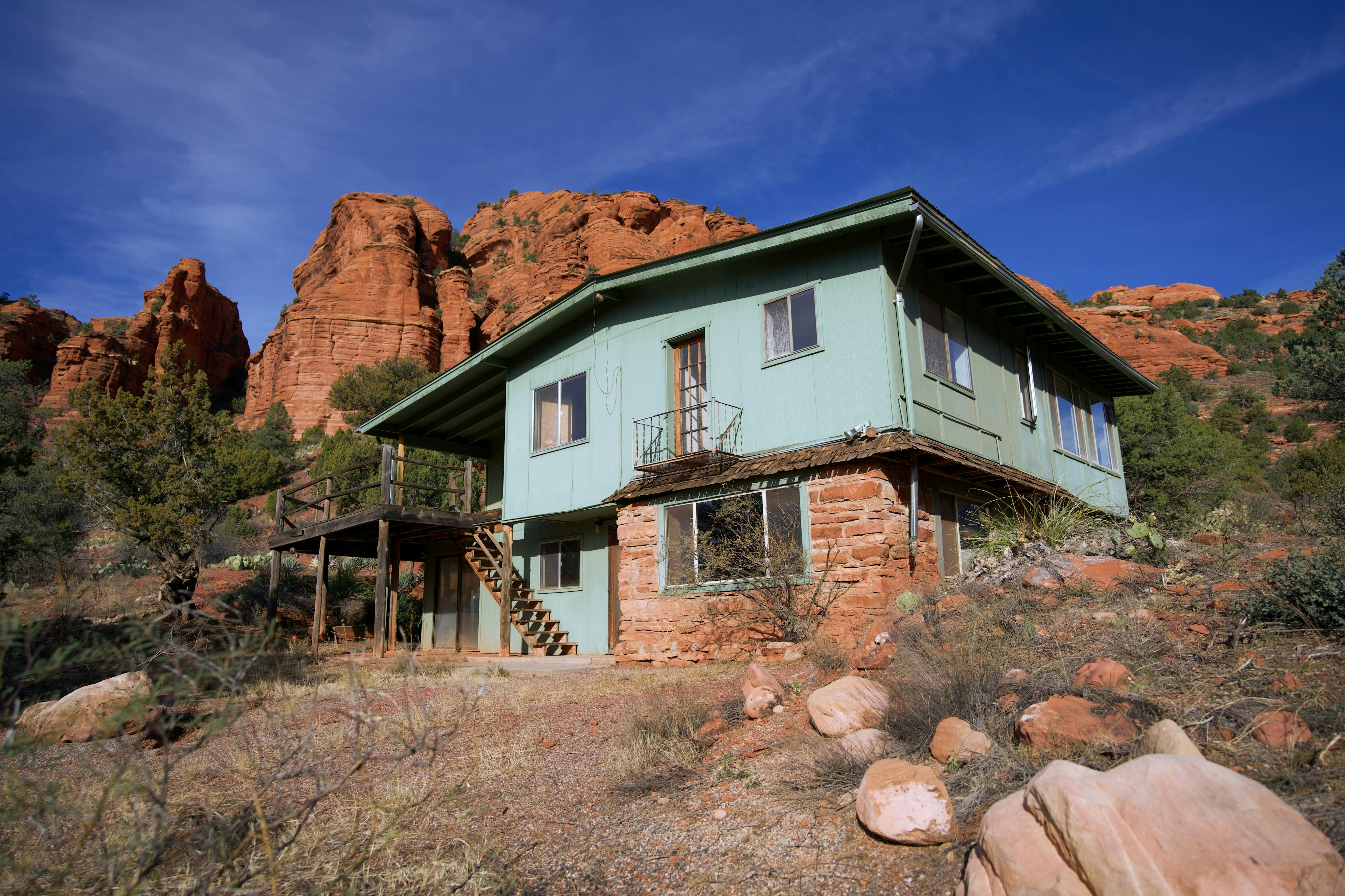 A green house sitting in the middle of a desert