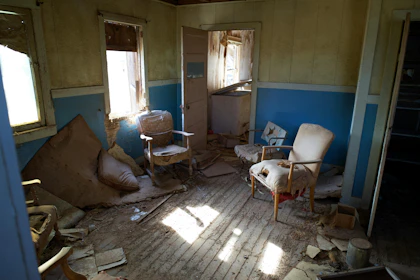 A room with a lot of furniture and broken windows