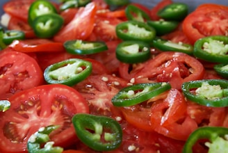 A close up of a pile of tomatoes and peppers