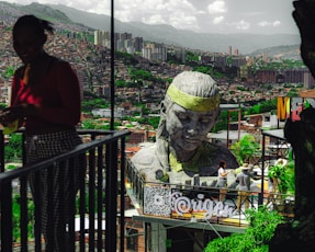 A woman standing next to a statue of a man