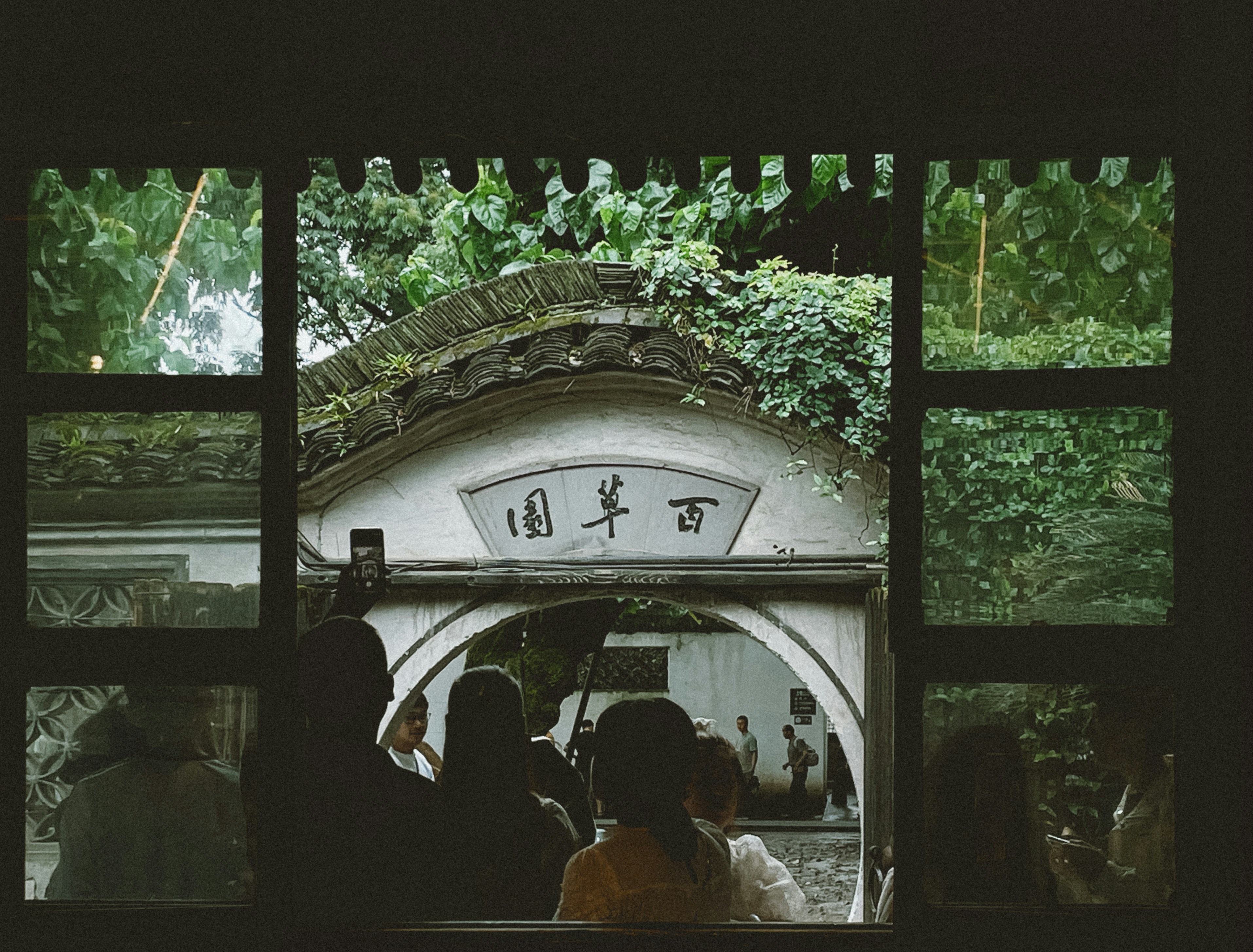 A group of people standing in front of a window