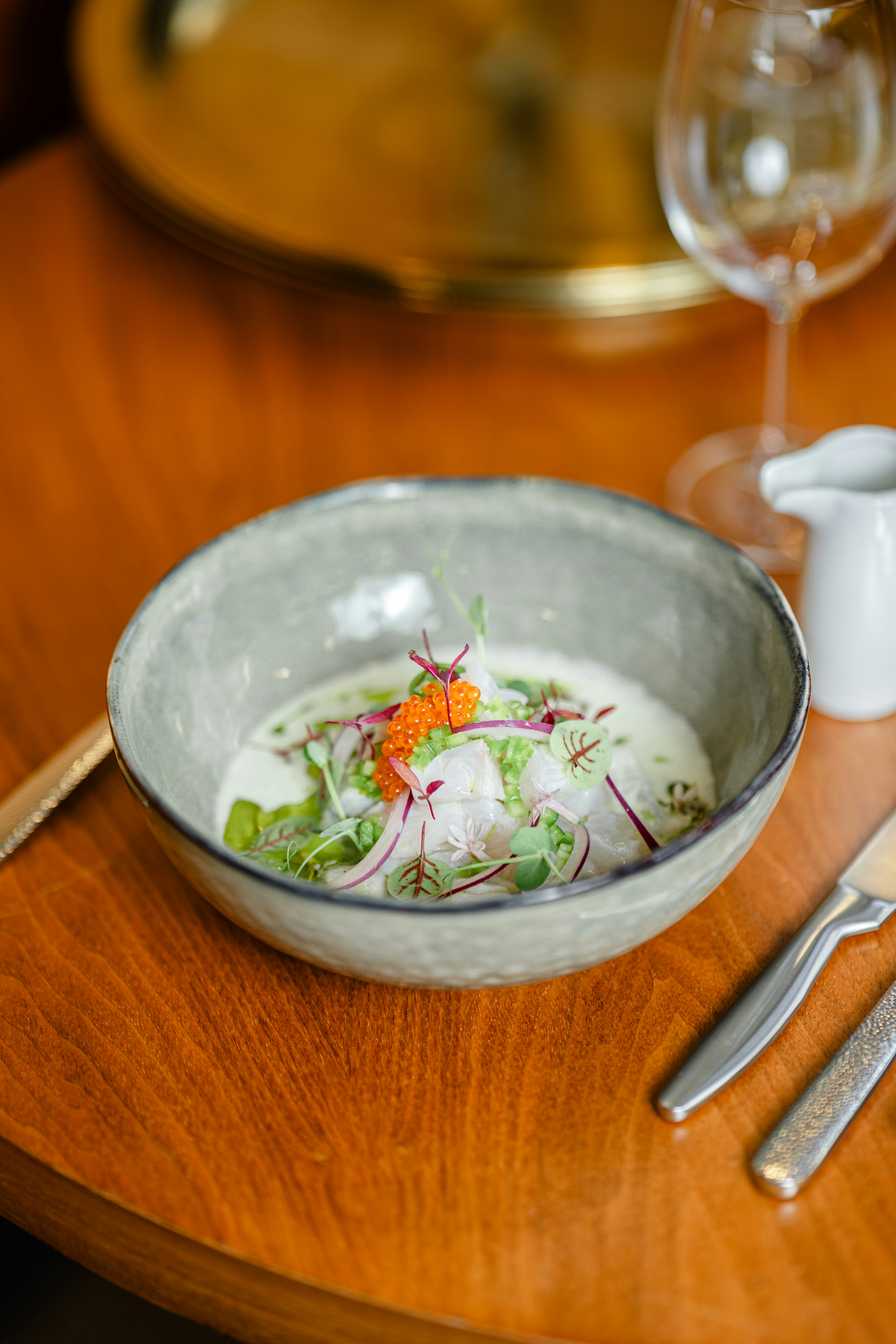 A wooden table topped with a bowl of food