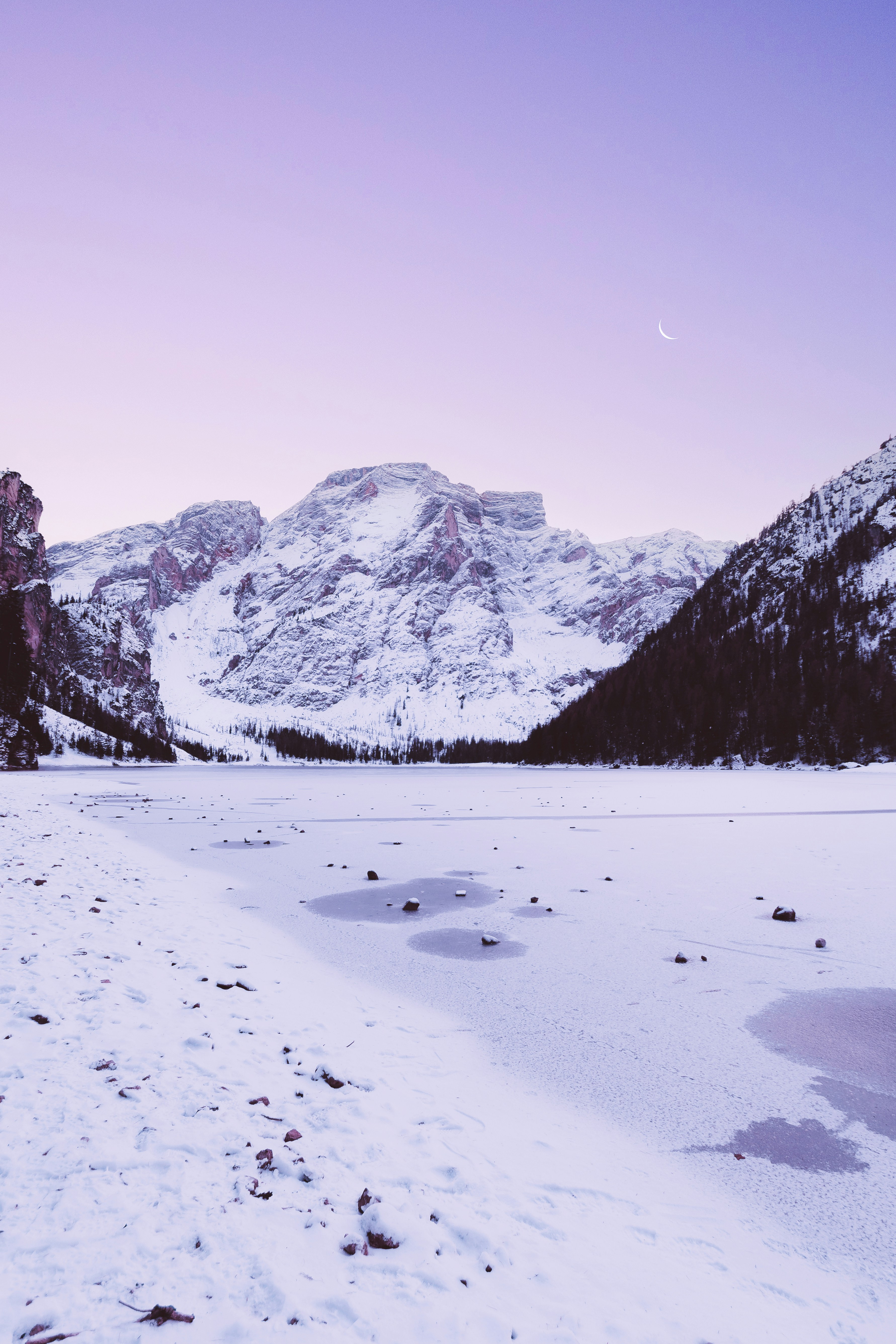 A snow covered field with mountains in the background