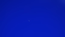 A plane flying in the sky with a moon in the background