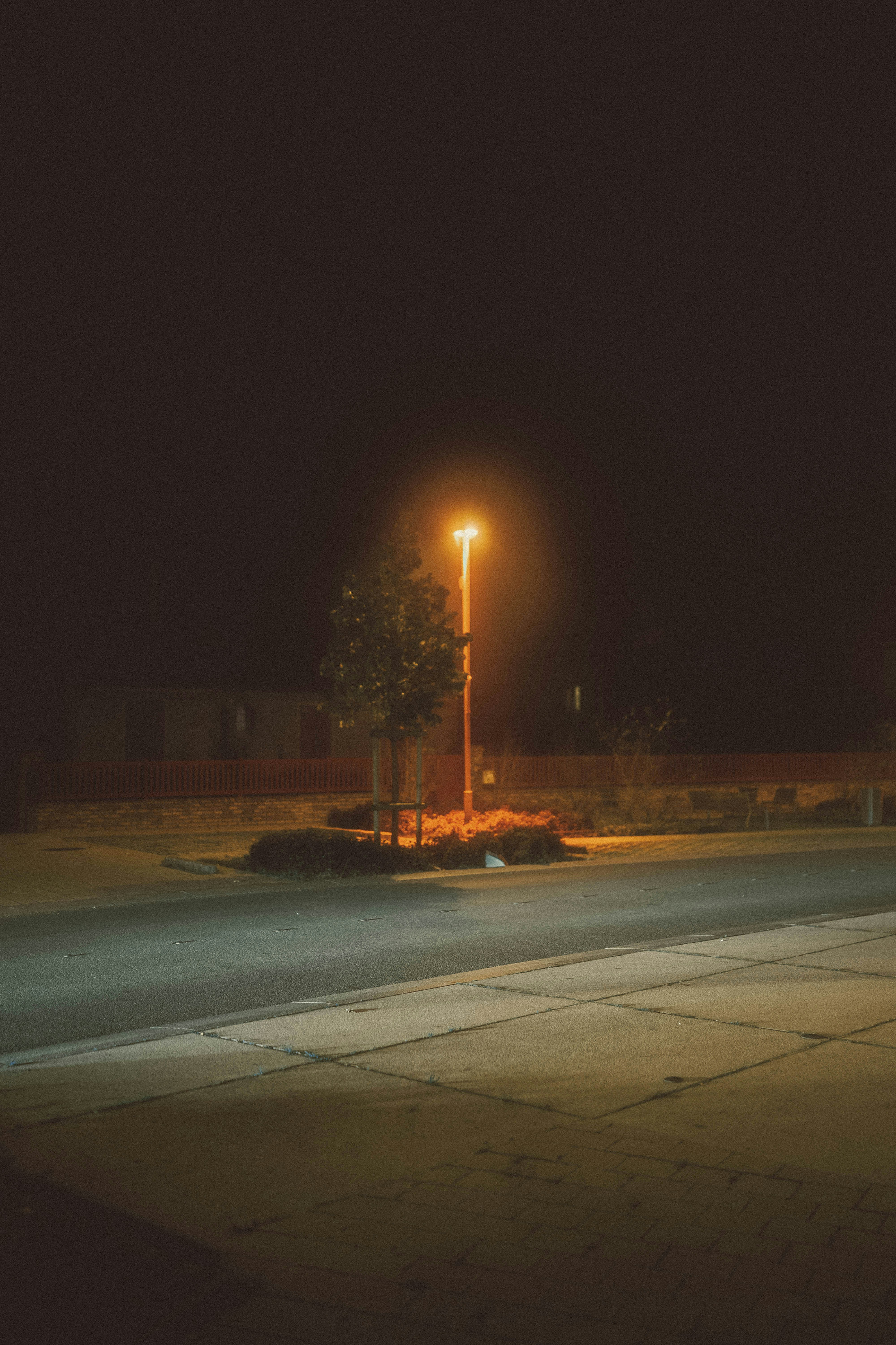 An empty street at night with a street light