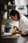 A woman in a kitchen preparing food on a cutting board
