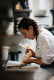 A woman in a kitchen preparing food on a cutting board