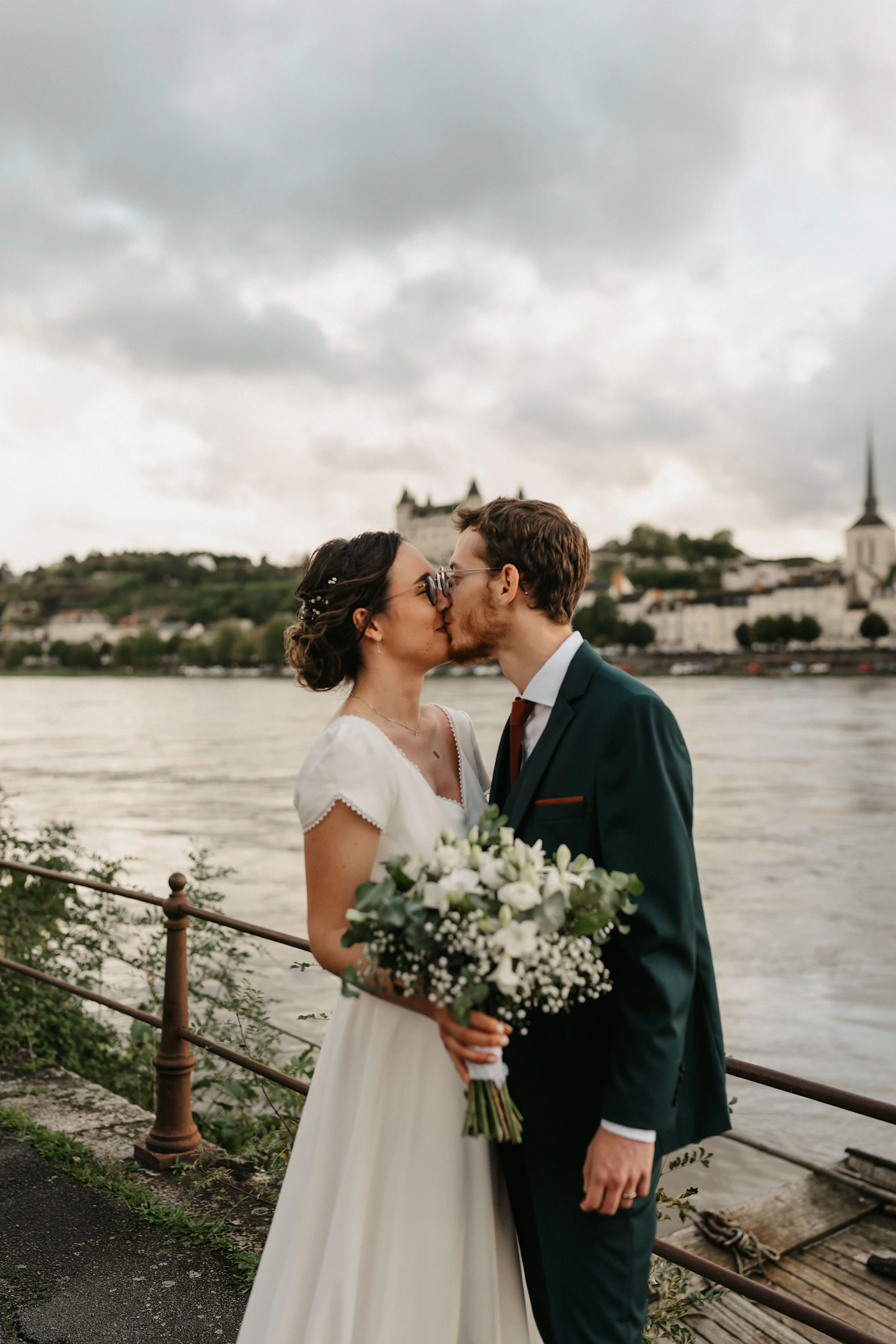 Couple exchanging symbolic ceremony vows in the Governors Garden of Old Quebec City with the stone fortification wall and the Chateau Frontenac visible behind them