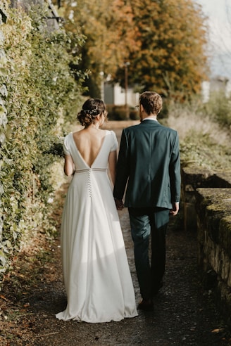 A bride and groom walking down a path