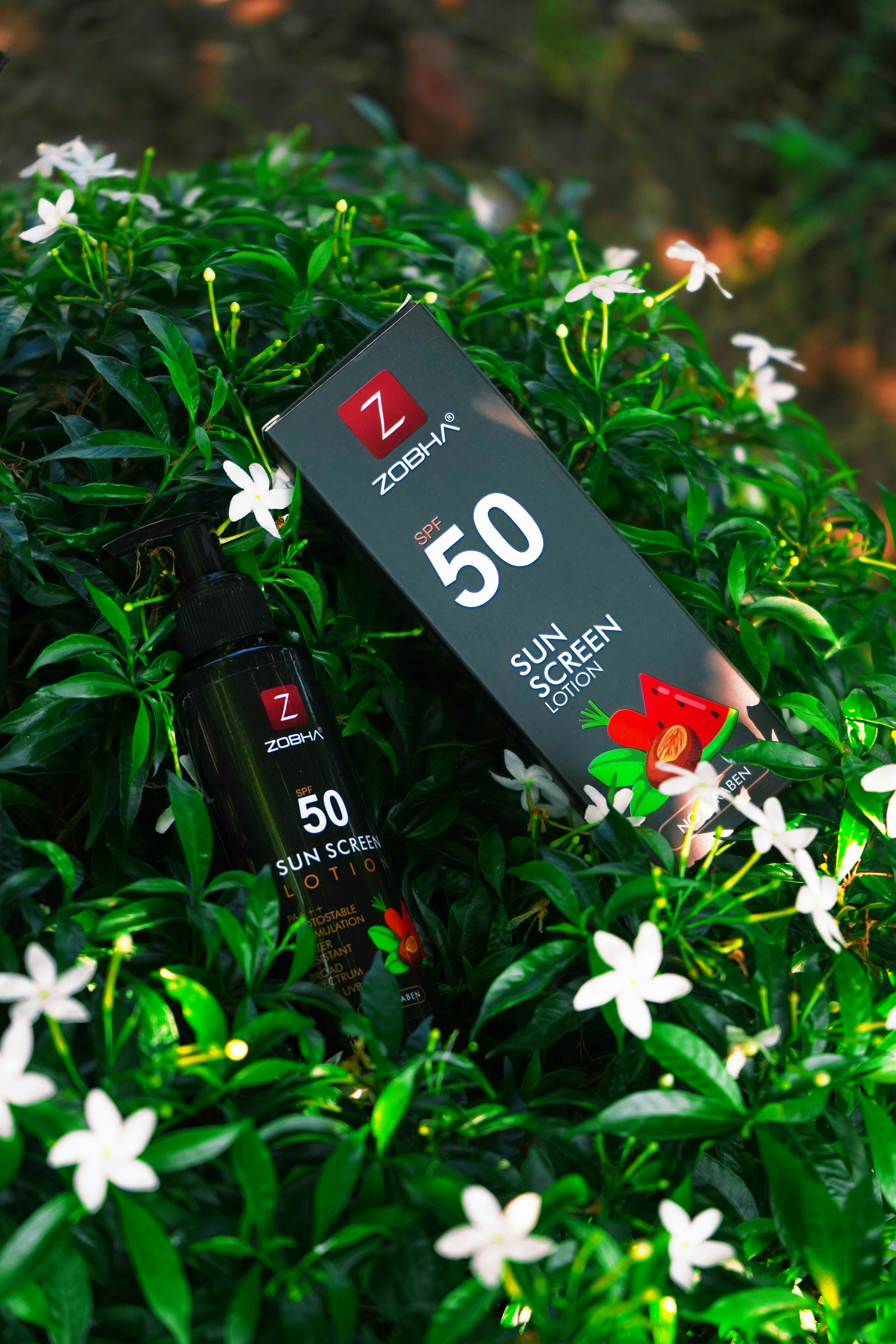 A bottle of perfume sitting on top of a lush green field