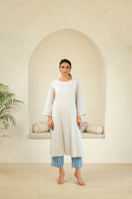 A woman standing in front of a white wall