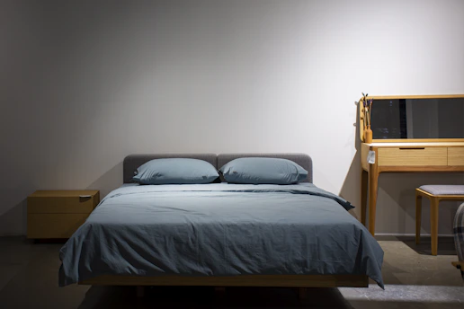 A bedroom with a bed, desk and mirror