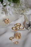 A bouquet of white flowers and some gold rings