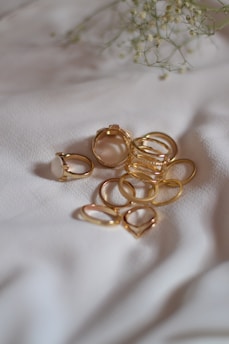 A bunch of gold rings laying on a white sheet