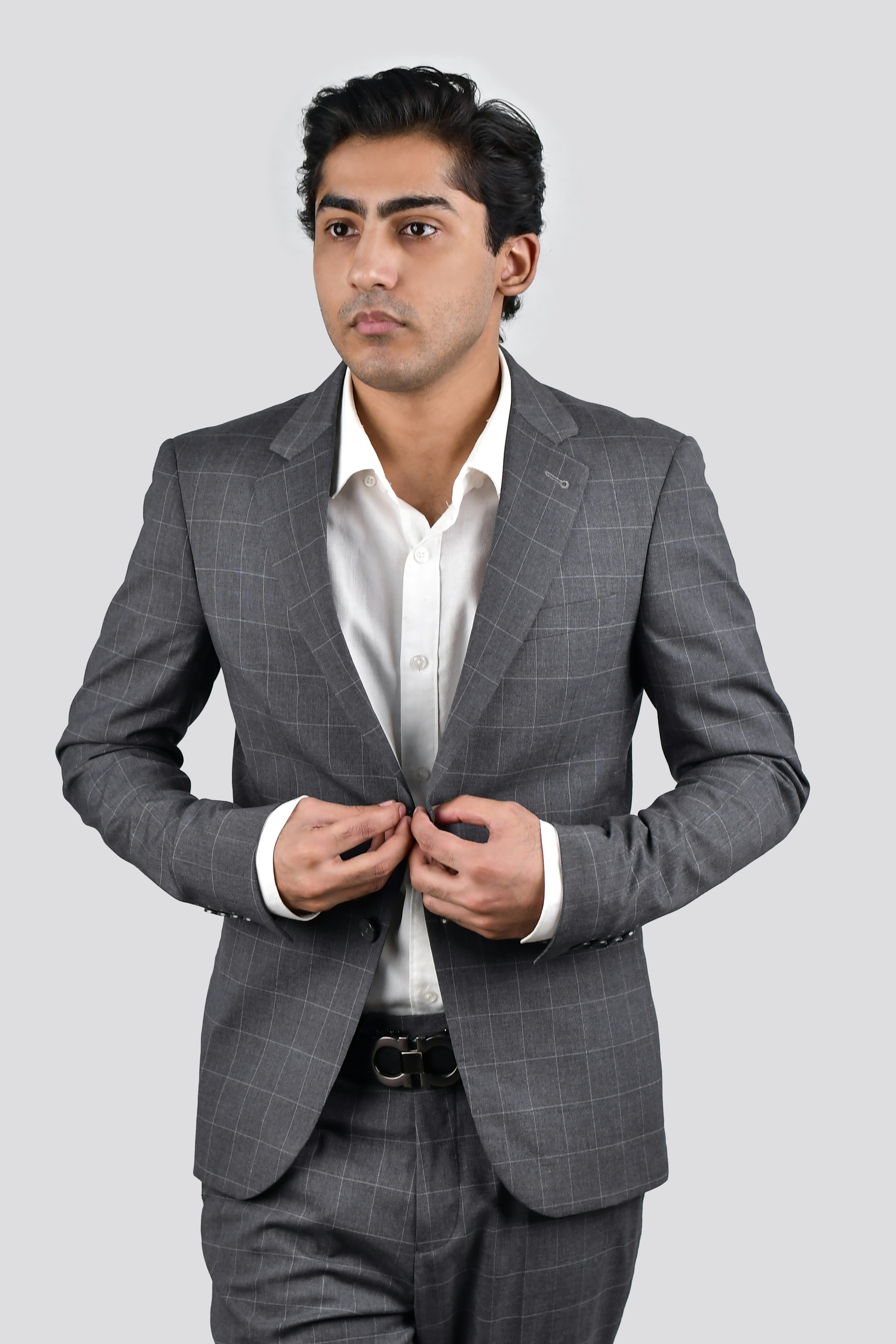 A man in a suit is standing with his hands in his pockets