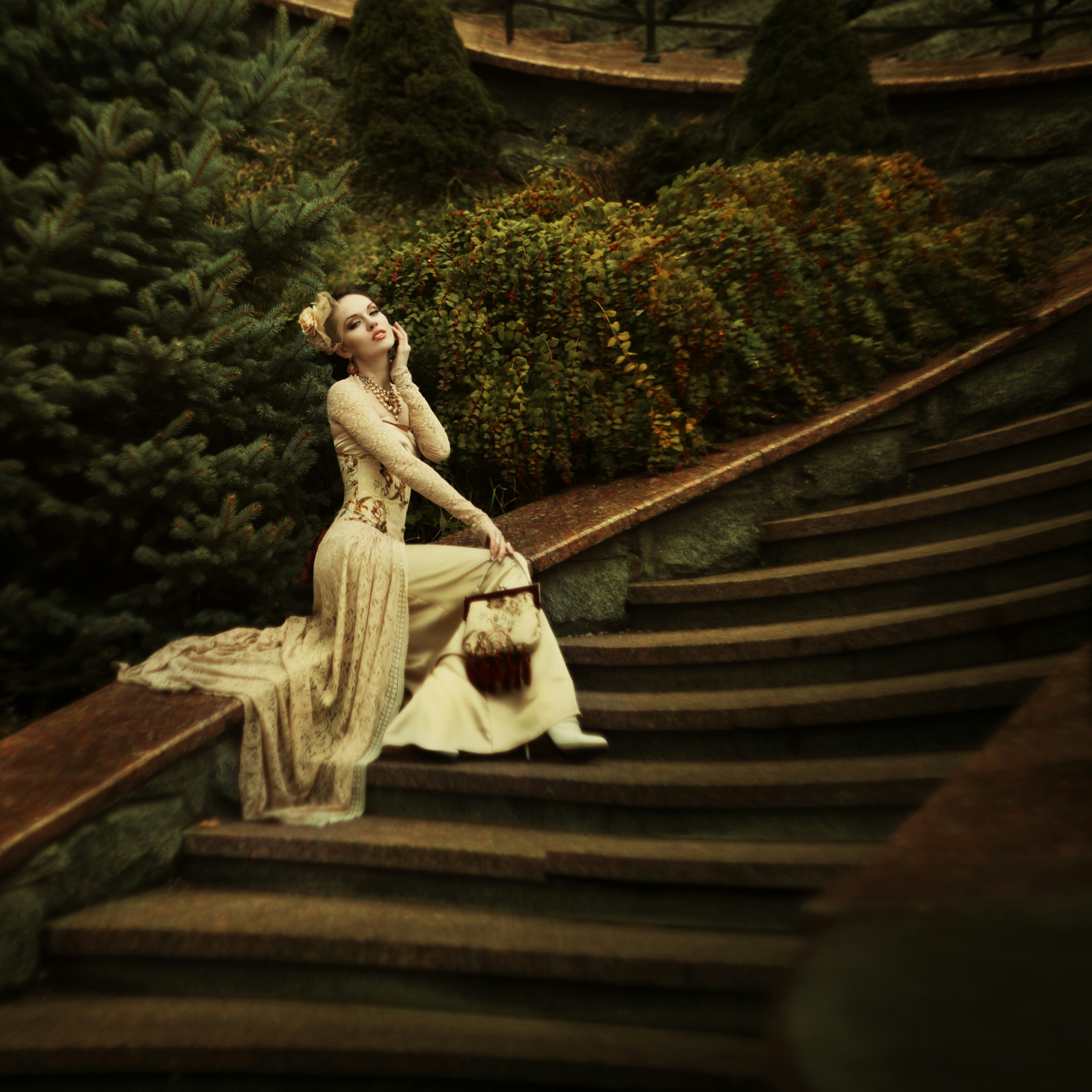 A woman in a dress sitting on a set of stairs