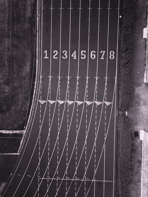 Runners competing on an outdoor track under stadium lights