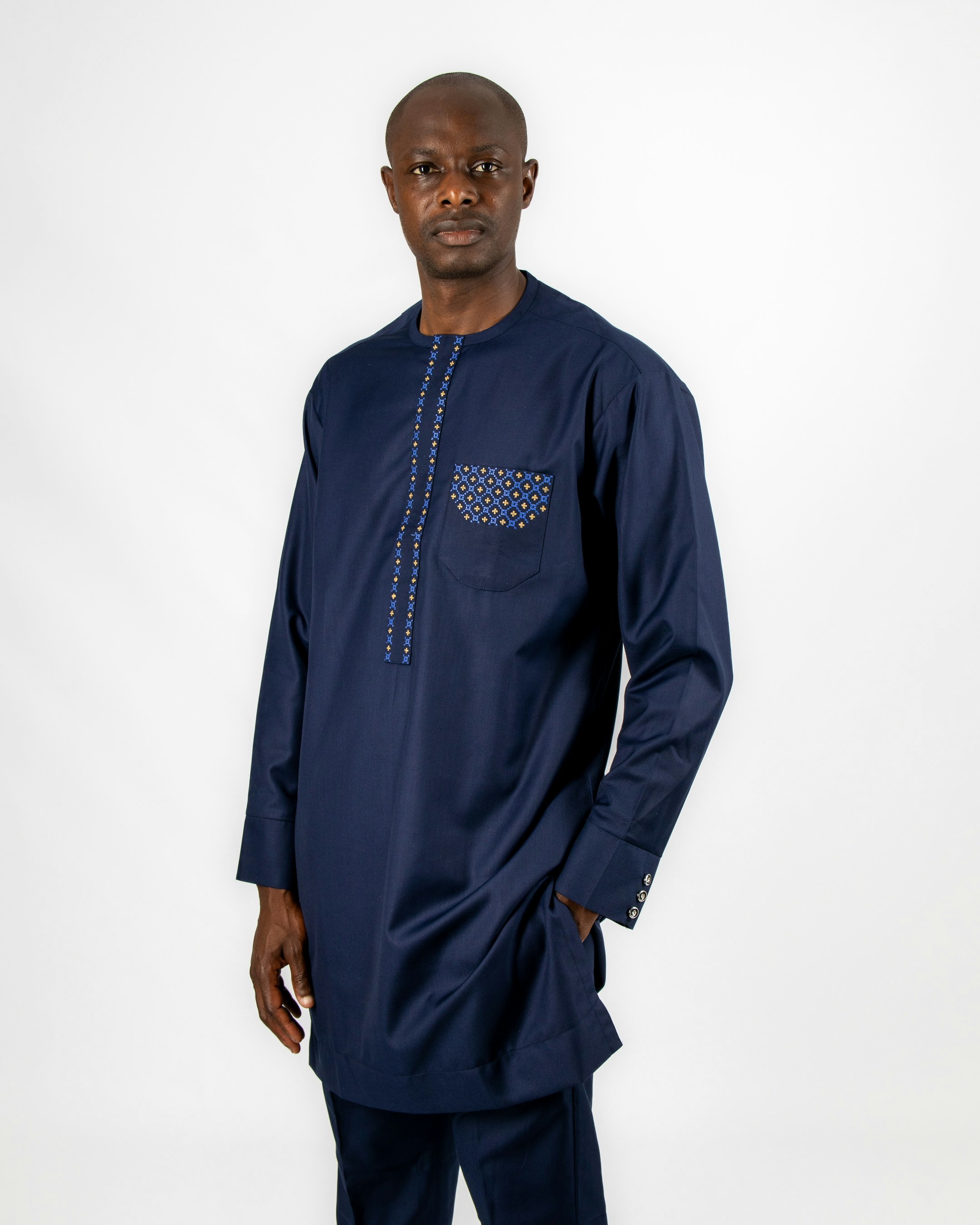 A man in a blue outfit standing in front of a white background