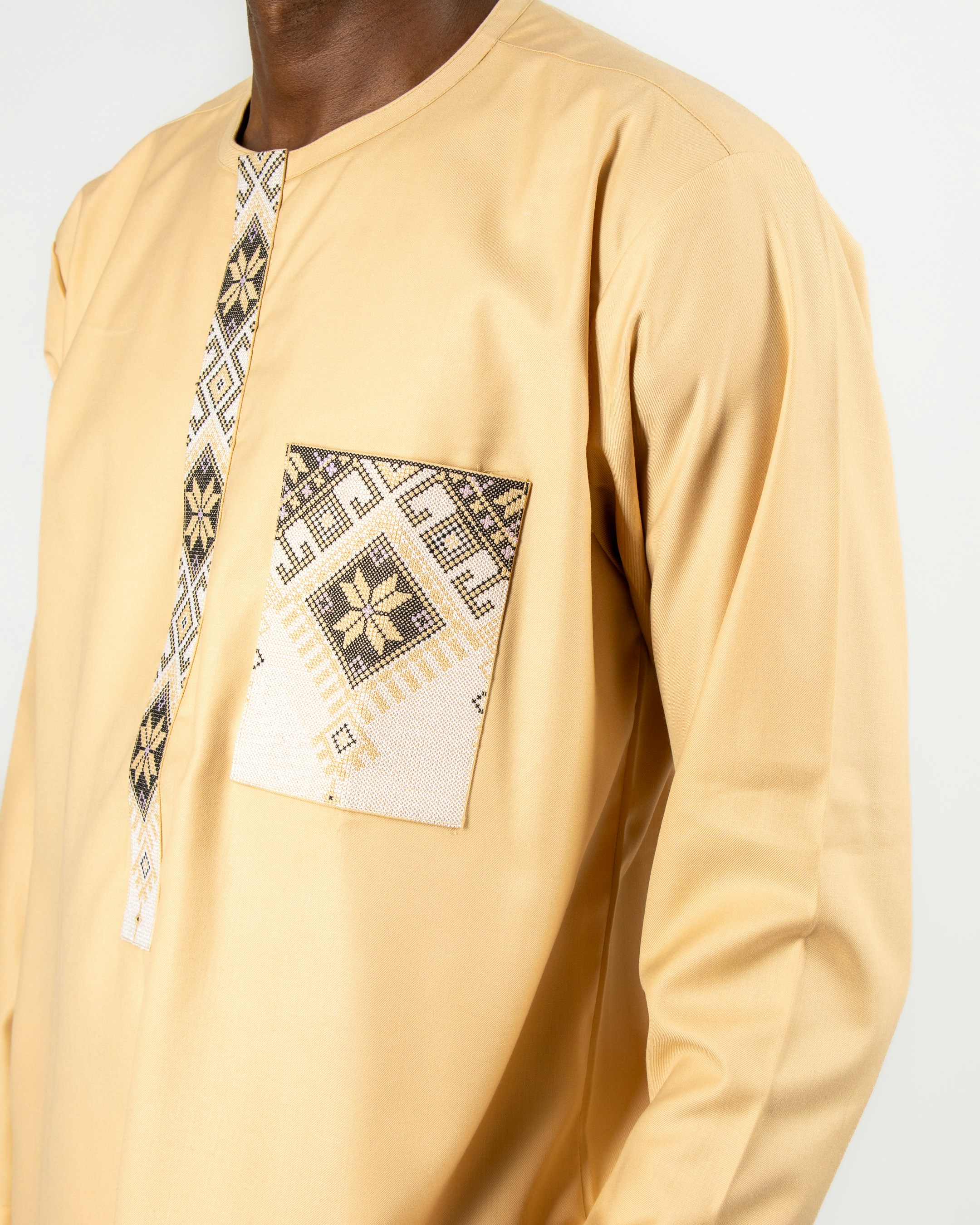 A man wearing a yellow shirt with a patch pocket