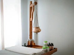 A wooden shelf with bottles and a wooden mannequin on it