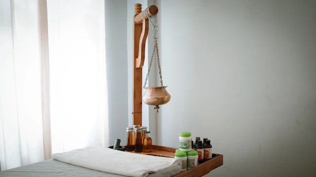Bàn trị liệu phủ vải lanh bên kệ gỗ đựng dầu