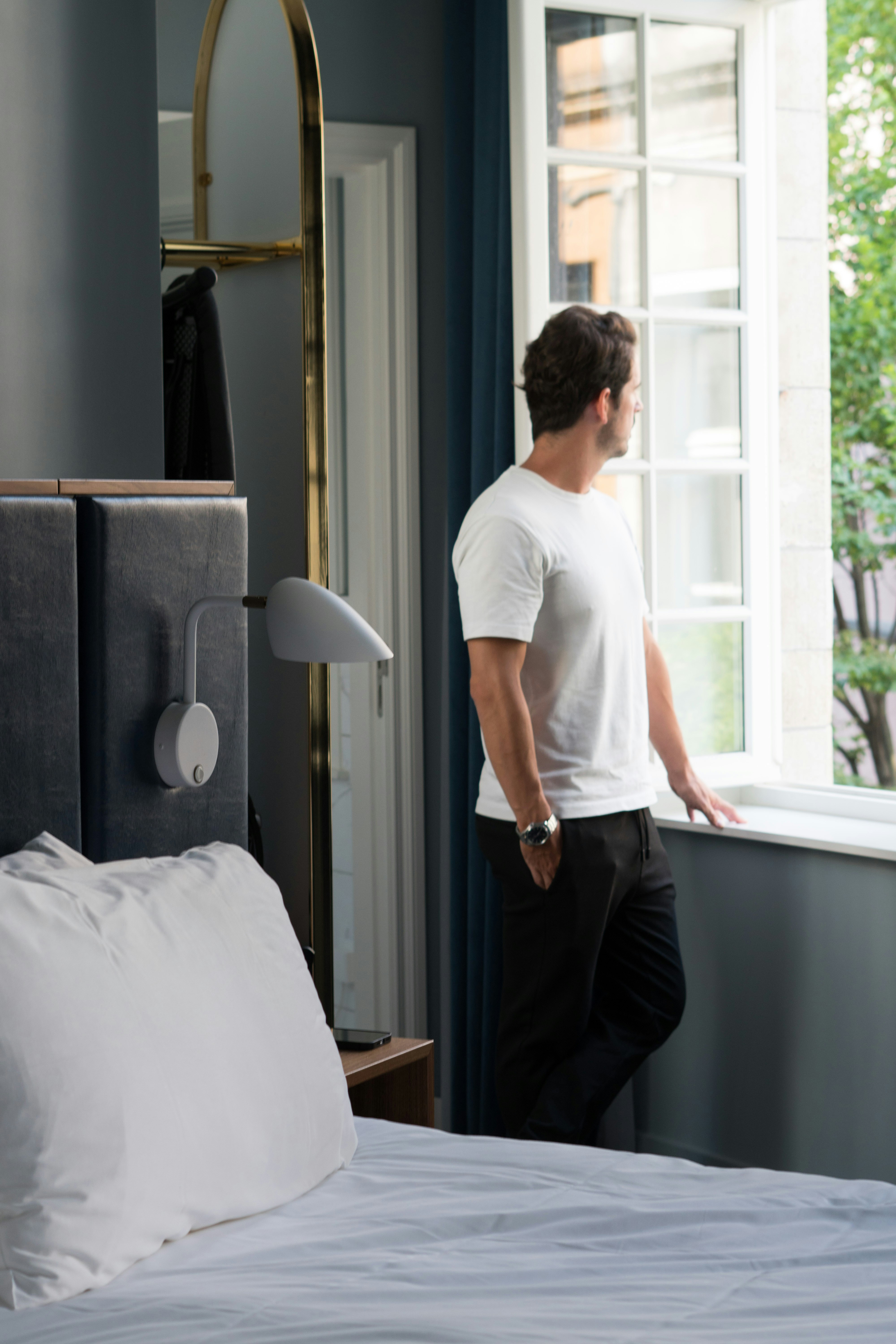 A man looking out of a bedroom window