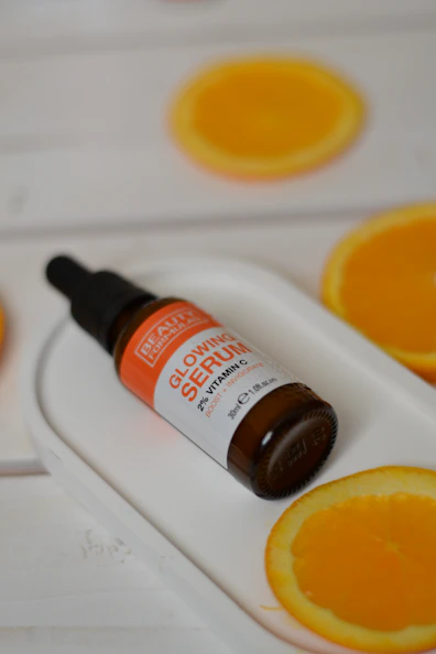 A bottle of vitamin oil sitting on top of an orange