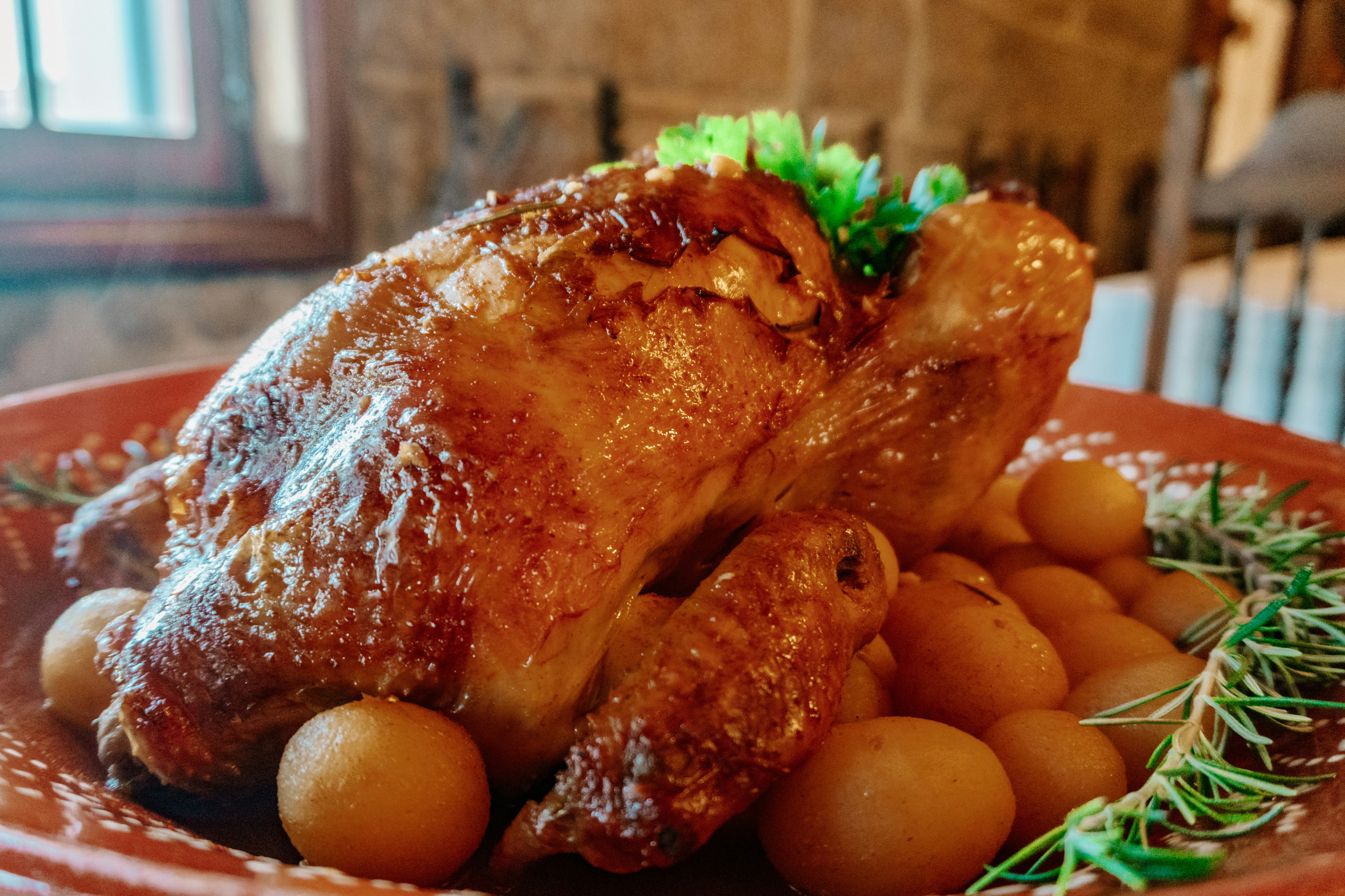 Warm golden herb-roasted chicken breast with roasted potatoes and green beans on rustic plate