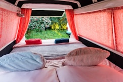 A bed in a small room with red curtains