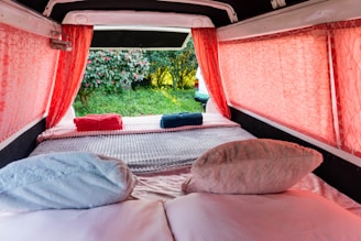 A bed in a small room with red curtains