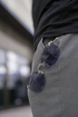 A pair of sunglasses attached to the side of a man's pants