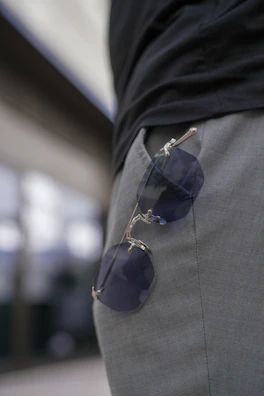 A pair of sunglasses attached to the side of a man's pants