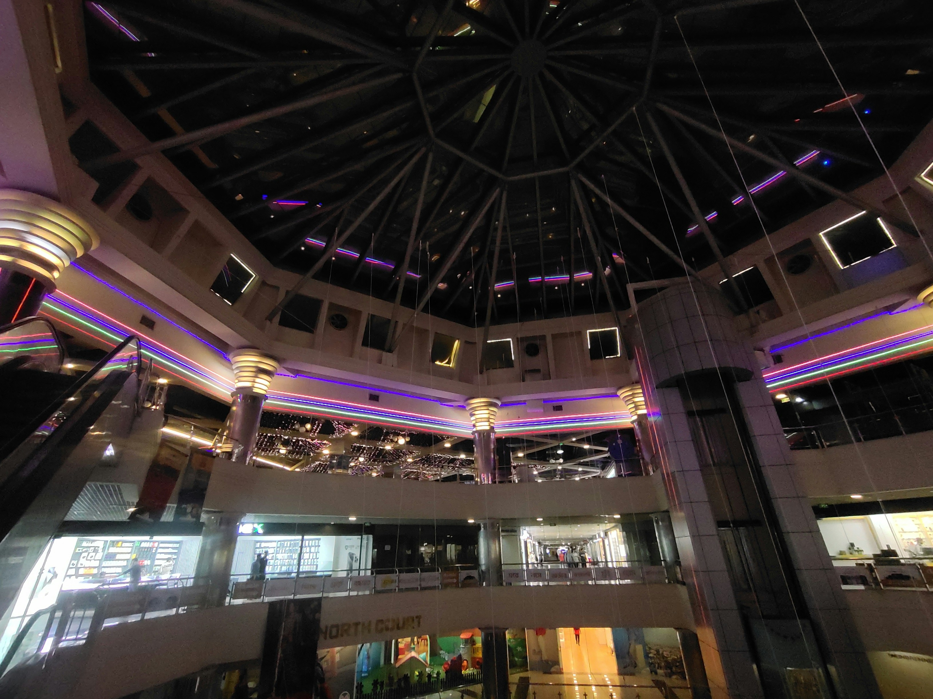 Large shopping mall with dramatic neon installation lighting in vibrant colors