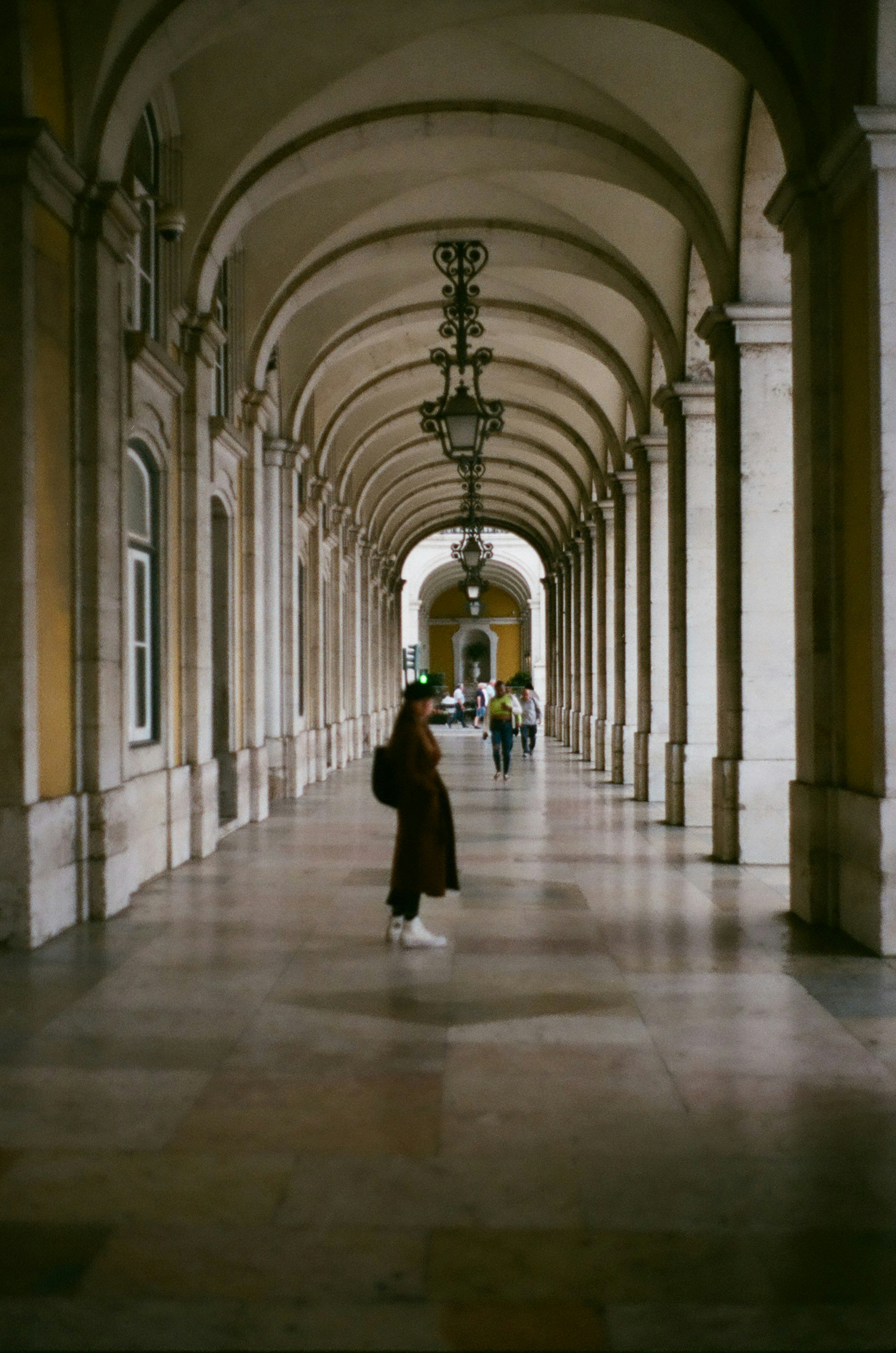 A woman is walking down a long hallway