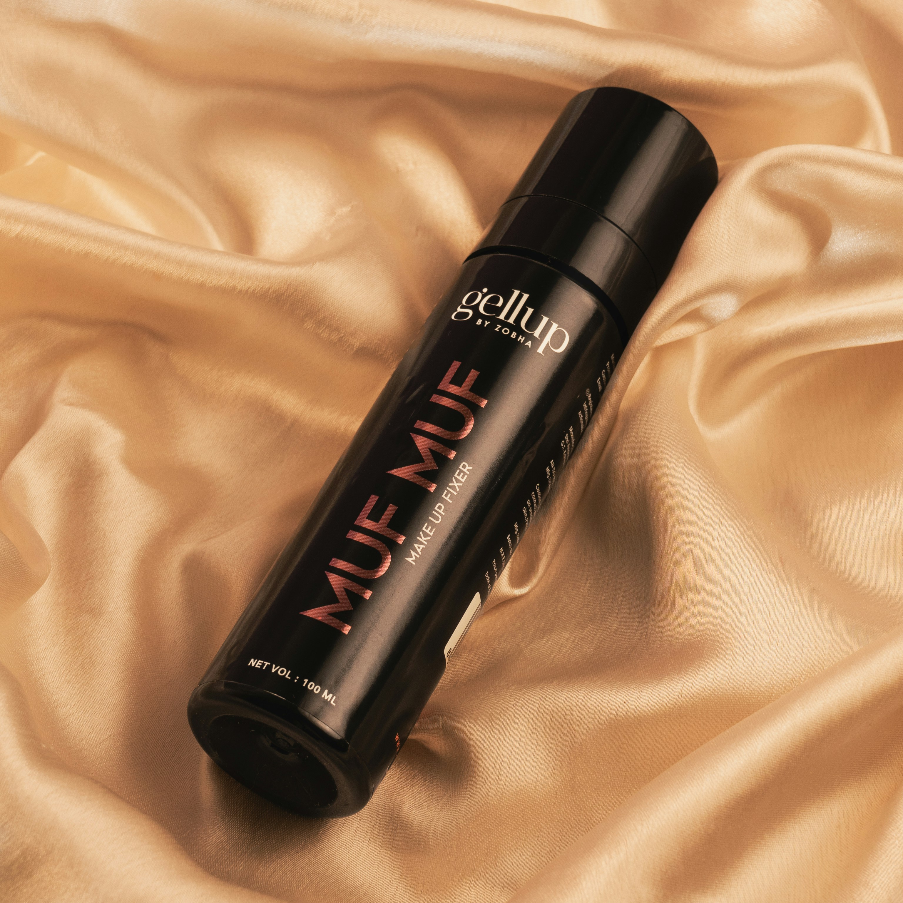 A bottle of hair product sitting on top of a bed