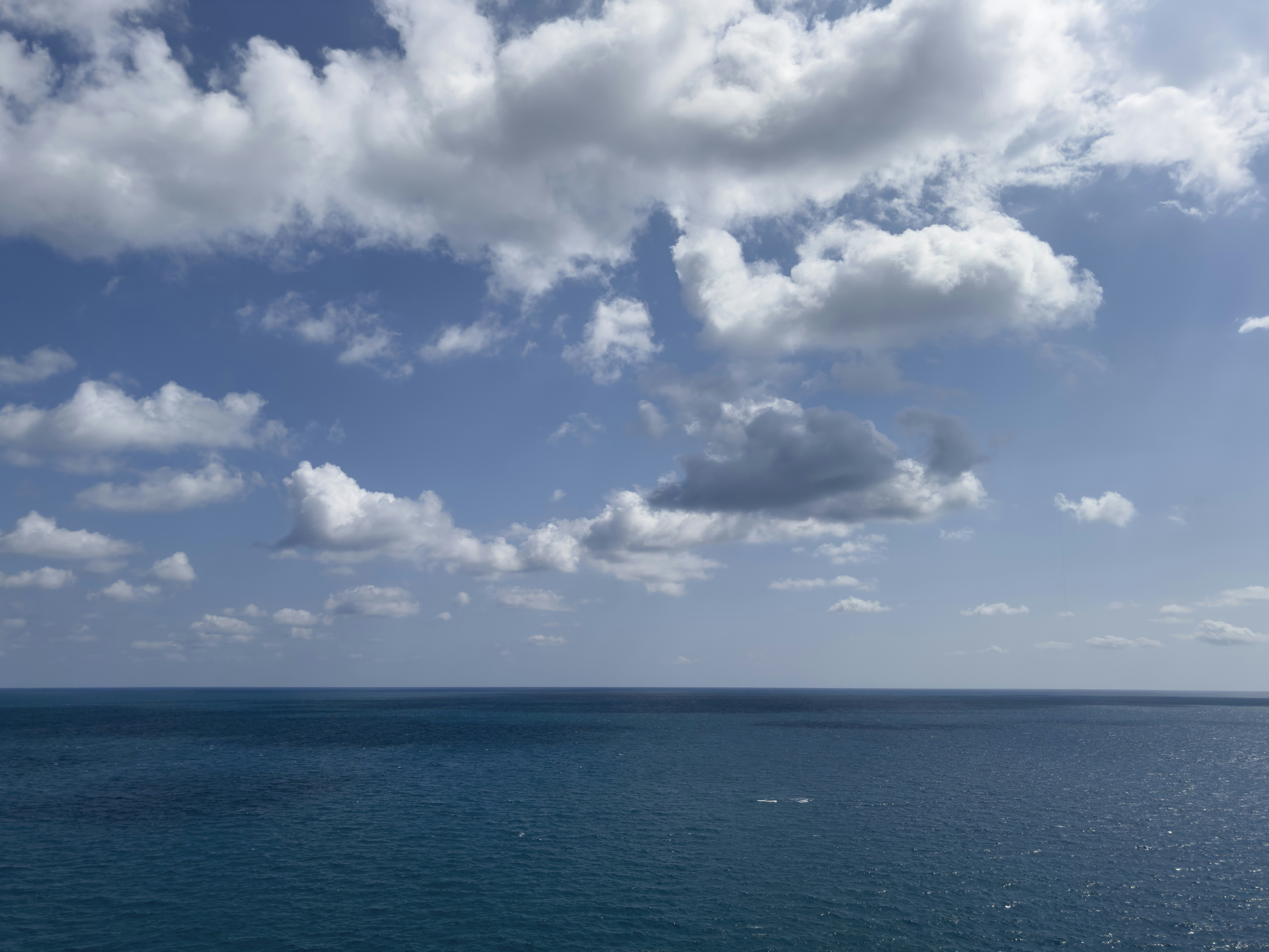 A large body of water under a cloudy blue sky