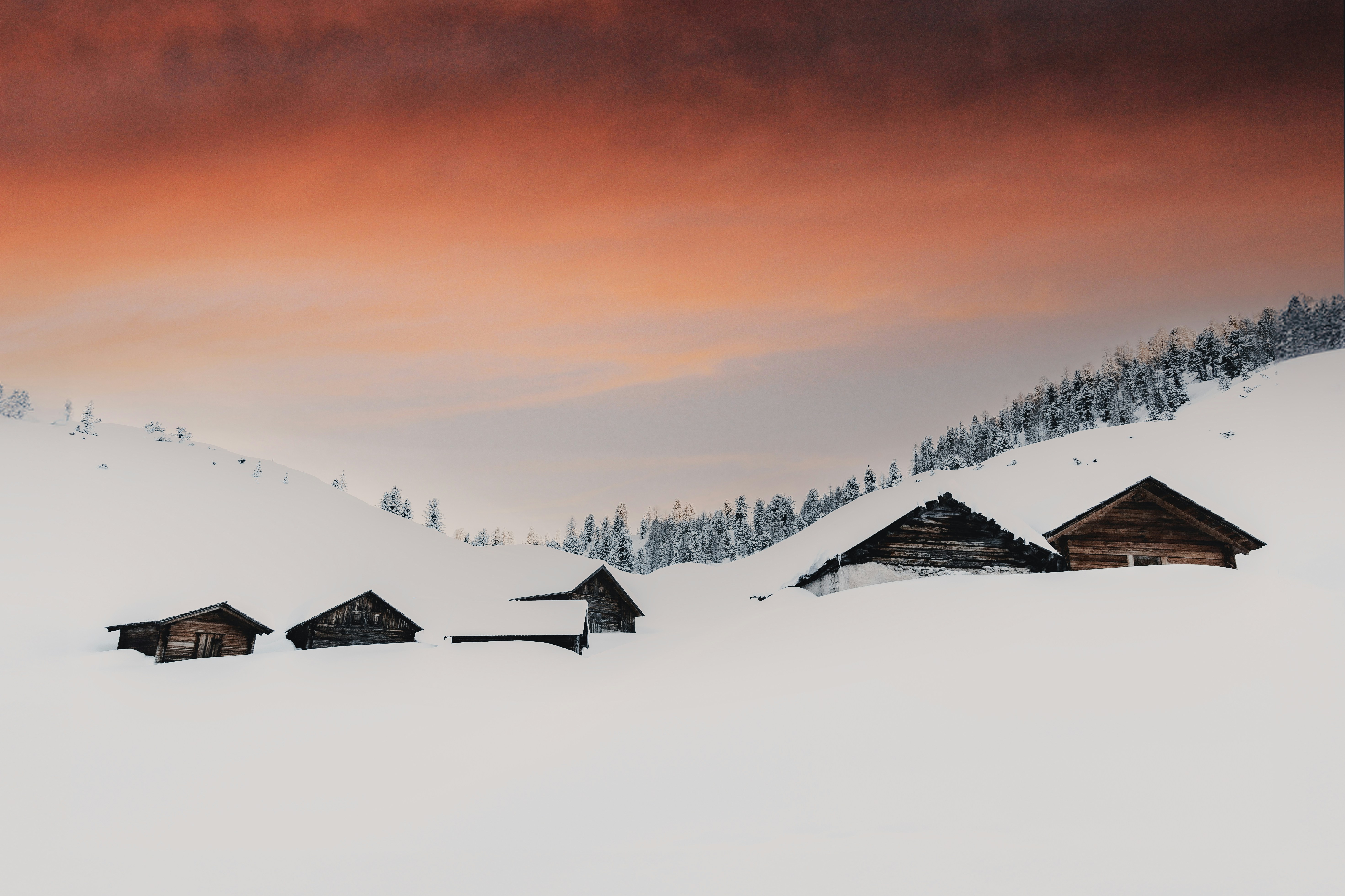 A group of houses sitting on top of a snow covered slope
