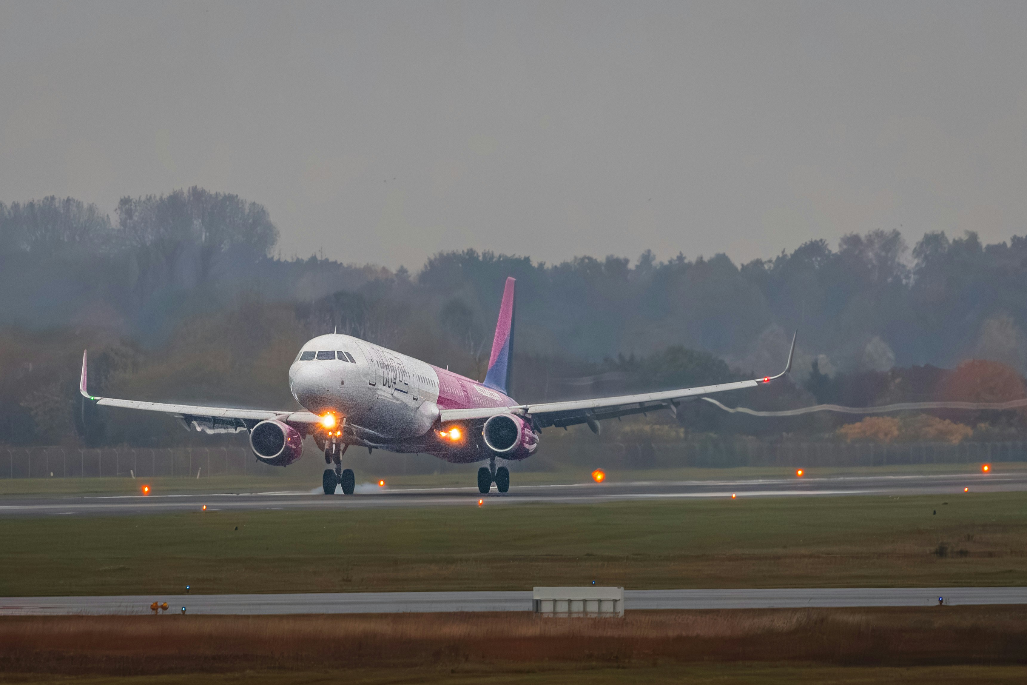 A large jetliner sitting on top of an airport runway, Wizz Air plane landing in Hamburg