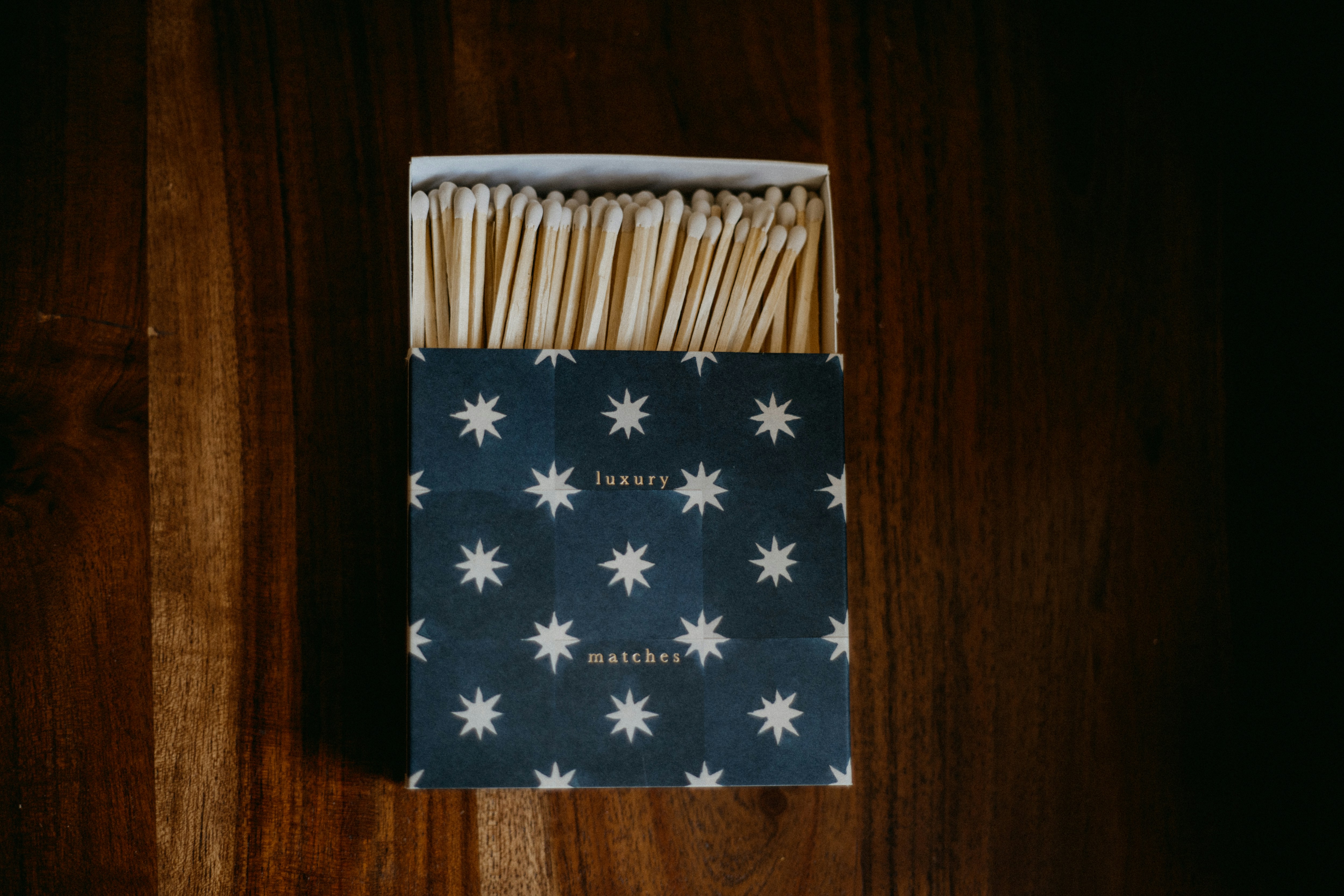 A box of matches sitting on top of a wooden table
