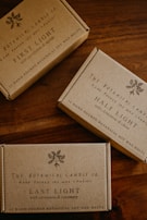 Three boxes of soap sitting on top of a wooden table