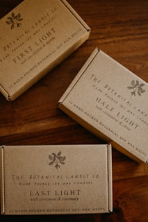 Three boxes of soap sitting on top of a wooden table