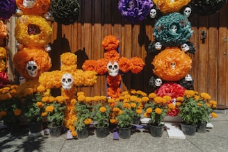 Day of the dead in Mexico A bunch of fake flowers that are on a fence