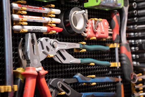 A bunch of tools are hanging on a rack