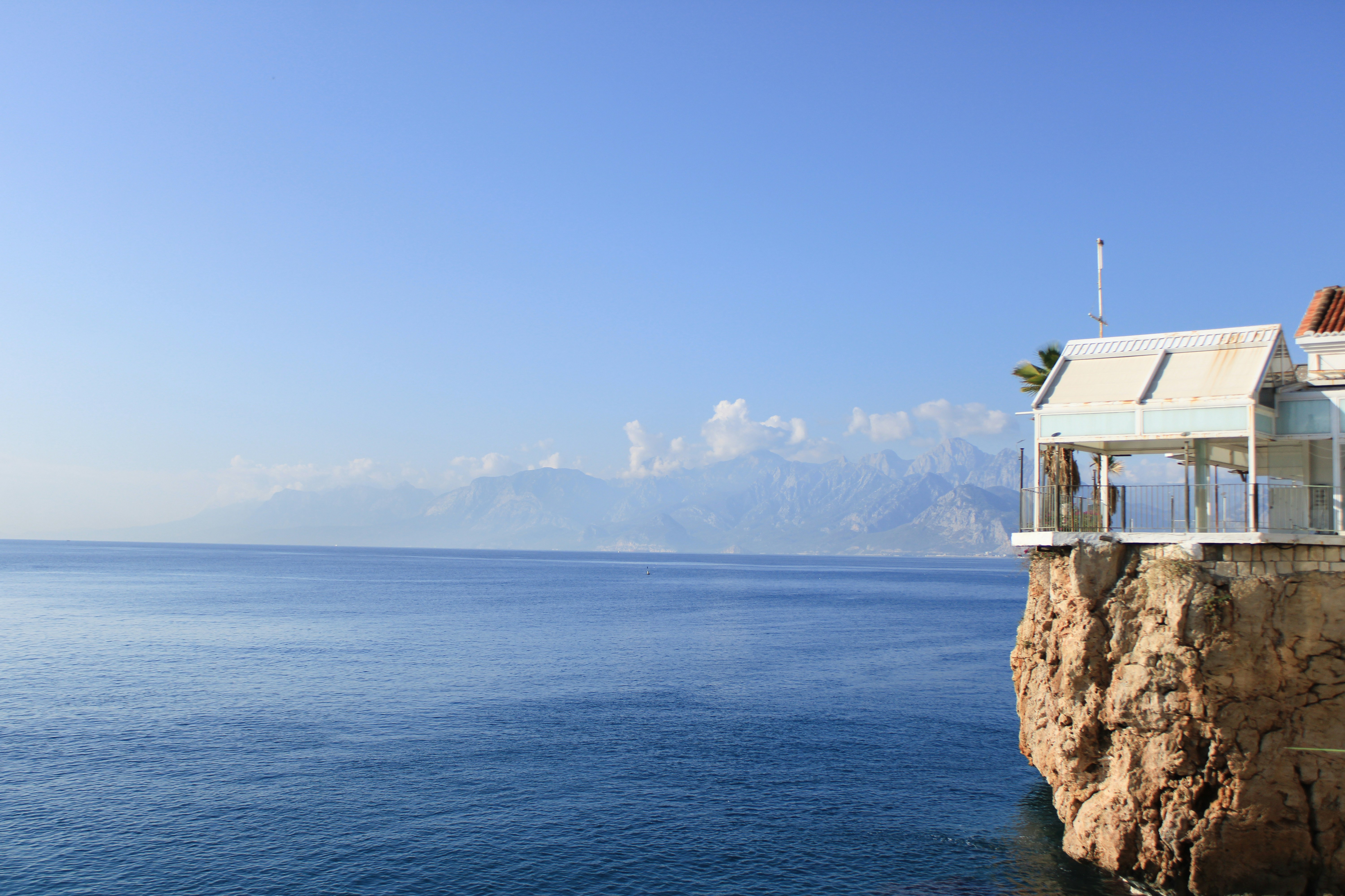 A house sitting on top of a cliff next to the ocean