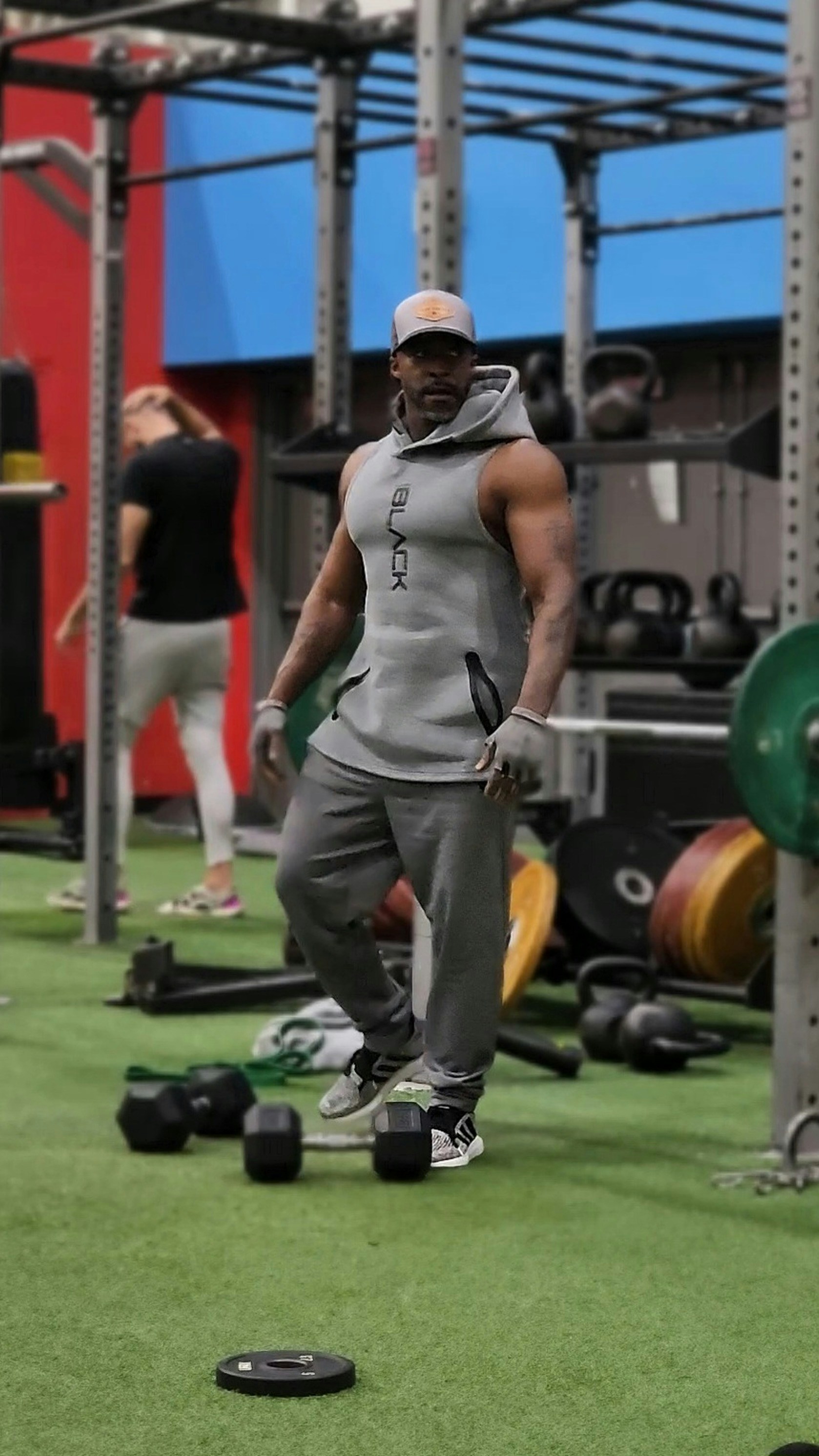 A man standing in a gym holding a barbell