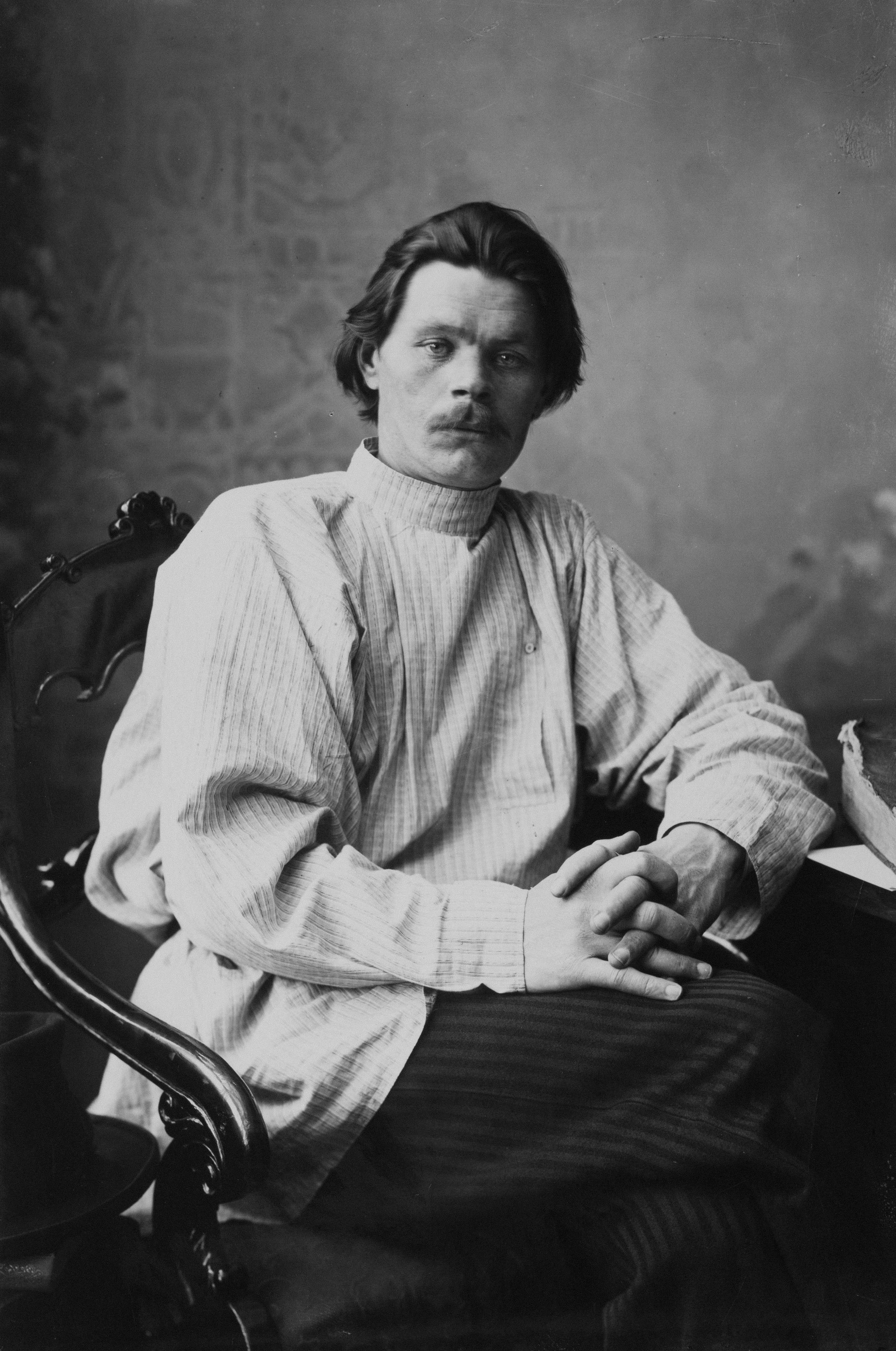 Man in traditional clothing sitting in a chair.