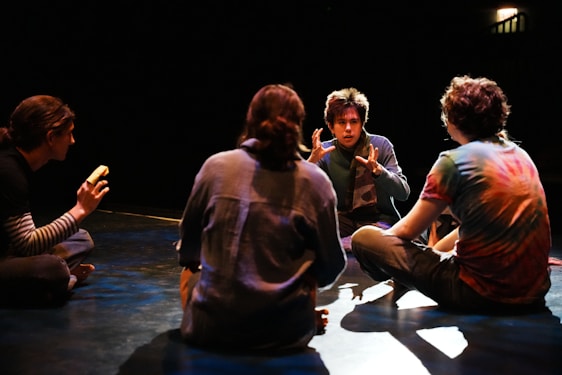 A group of people sitting on the floor talking