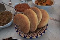 A table topped with bowls and plates of food
