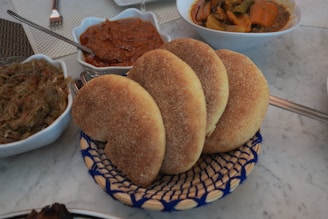 A table topped with bowls and plates of food
